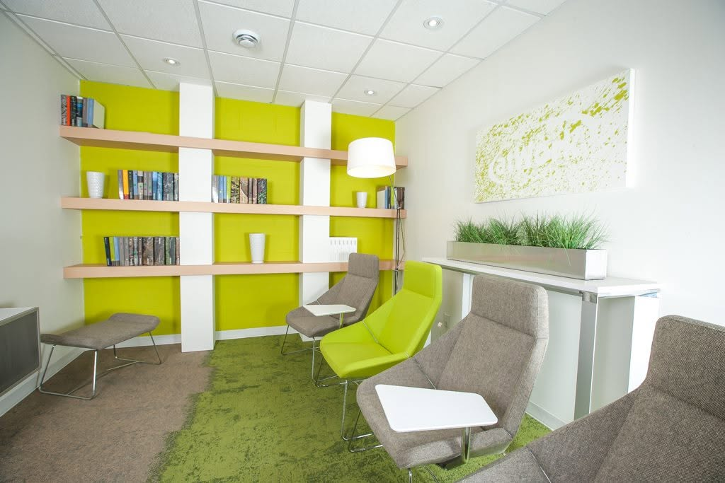 Bright commercial lounge with green accent wall and modern seating